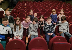 Uczniowie siedzą na fotelach w teatrze