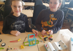 Dwie uczennice składają model z klocków.