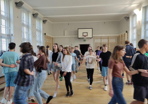 Uczniowie w trakcie próby tańca na sali gimnastycznej.