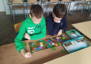 Dwóch uczniów gra w grę planszową.