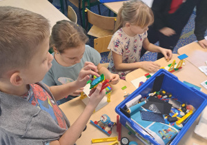Dwuch chłopców i dwie dziewczynki budują zklocków lego