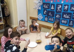 Cztery dziewczynki i trzech chłopców przy herbatce