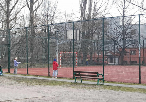 Uczniowie przy boisku szkolnym.