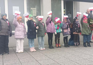 Uczniowie klas młodszych z biało-czerwonymi serduszkami.