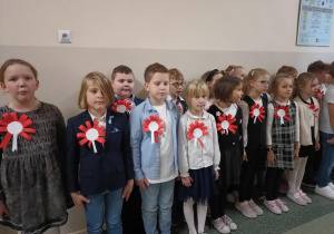 Uczniowie klas młodszych śpiewają hymn.