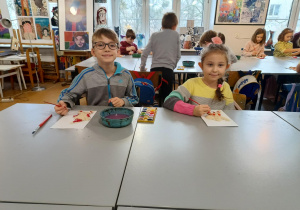 Chłopiec z dziewczynką malują swoje prace.