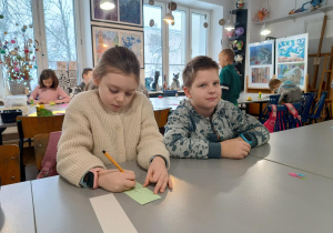 Chłopiec i dziewczynka projektują zakładki do książek