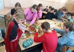 Dzieci wykonują wspólnie pracę.