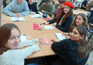 Grupa uczniów siedzi przy dużym stole.