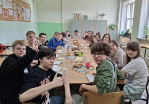 Uczniowie klasy 7 siedzą przy stole.