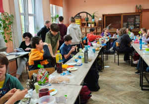 Uczniowie klasy 6 siedzą przy stole.