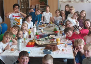 Uczniowie klasy 4 pozują na tle stołu.
