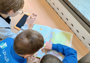 Trzej chłopcy szukają państw europejskich.
