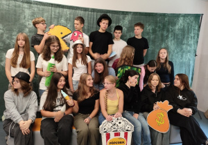 Klasa z rekwizytami przygotowuje się do zdjęcia klasowego.