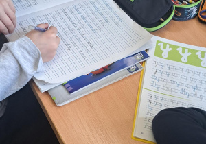 Uczniowie uzupełniają kaligrafię