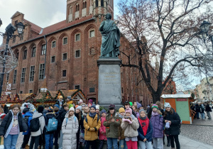 Grupa uczniów przed pomnikiem Mikołaja Kopernika