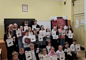 Grupa uczniów pozuje do zdjęć z dyplomami