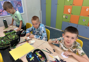 Trzech chłopców z 1b rysuje na karteczkach