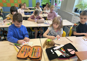Grupka uczniów z 1b rysuje coś na karteczkach