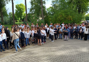 Dzieci oraz rodzice stojący w grupie.