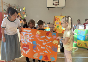 Grupa uczniów 1c wraz z wychowawczynią prezentuje plakat