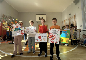 Grupa uczniów prezentuje plakat