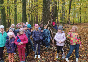 W leśnej scenerii grupa uczniów klasy I uśmiecha się do zdjęcia